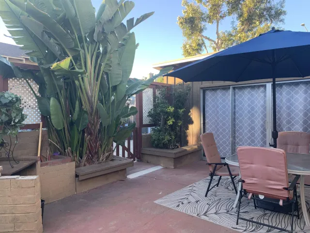 a view of a chairs and table in the back yard of the house