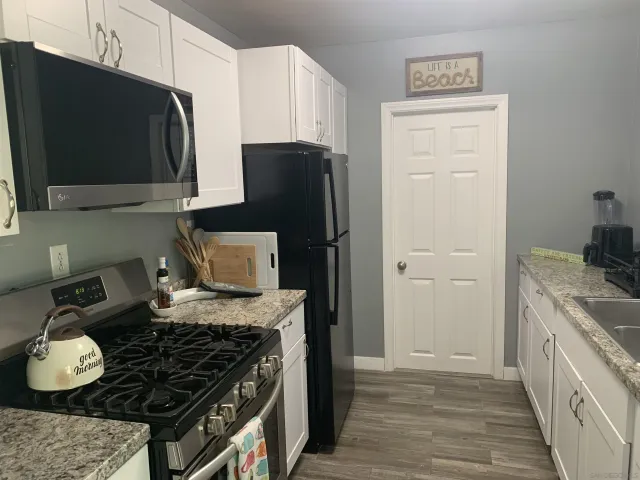 a kitchen with stainless steel appliances granite countertop a stove and a refrigerator