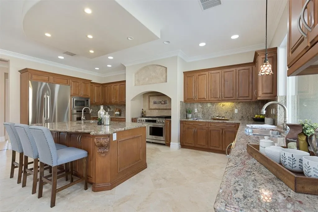 28310 Vía Santa Rosa Temecula, CA 92590 - Photo 14 of 23 a kitchen with stainless steel appliances granite countertop a stove top oven a sink a dining table and chairs with wooden floor