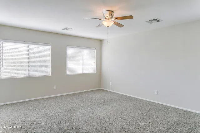 an empty room with a window and a fan