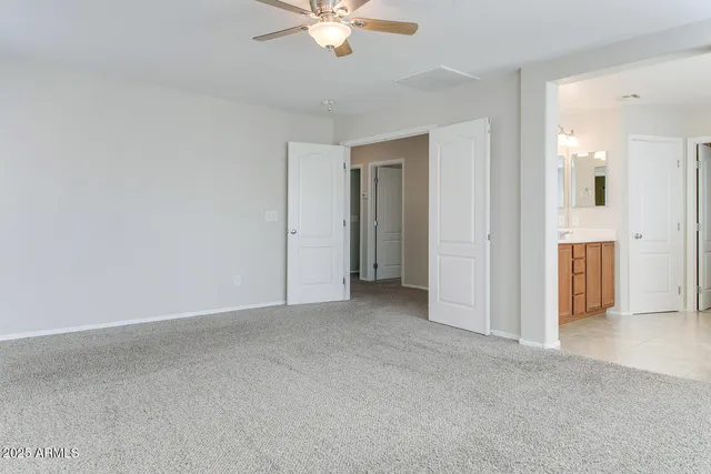 an empty room with fan and entrance