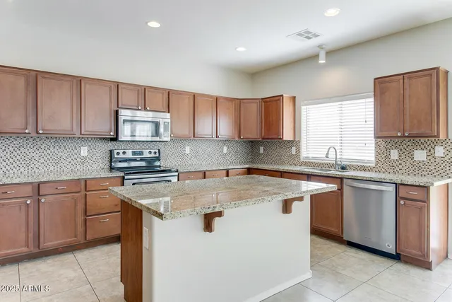 a kitchen with cabinets appliances a sink and a window