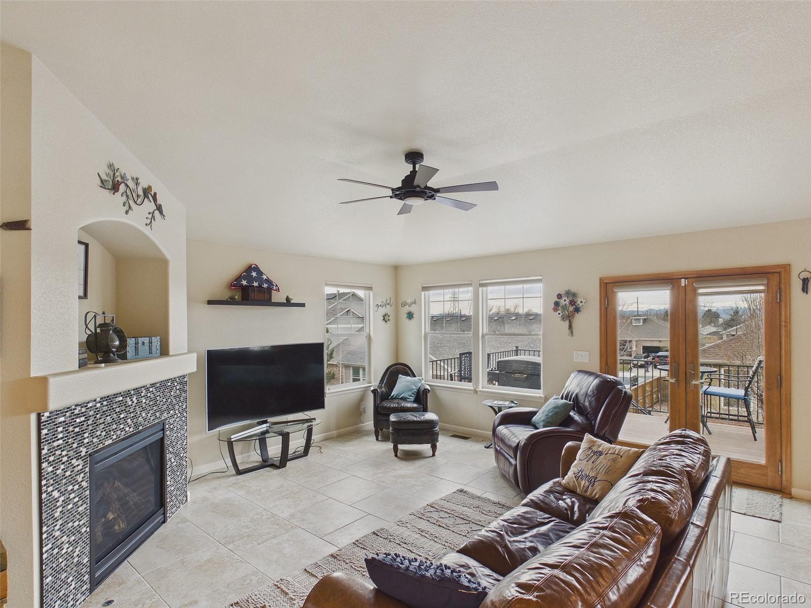 2805 South Jebel Way Aurora, CO 80013 - Photo 12 of 50 a living room with furniture a fireplace and a flat screen tv
