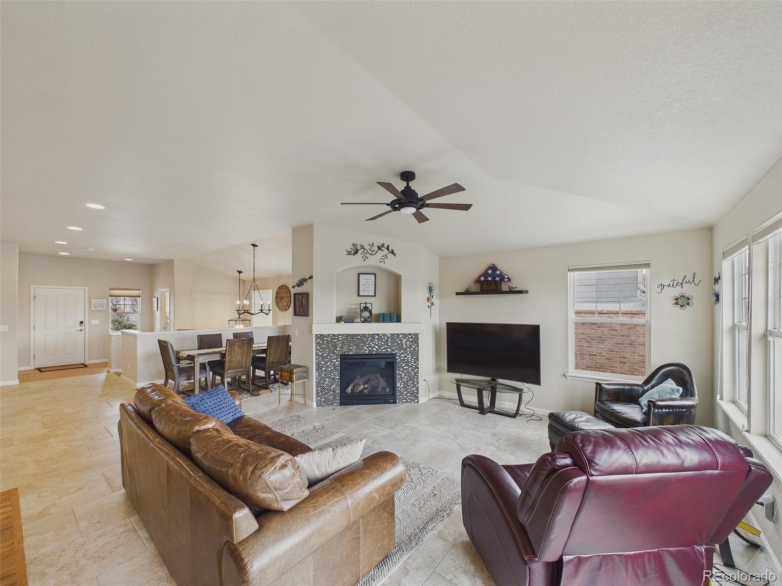 2805 South Jebel Way Aurora, CO 80013 - Photo 13 of 50 a living room with furniture a fireplace and a flat screen tv