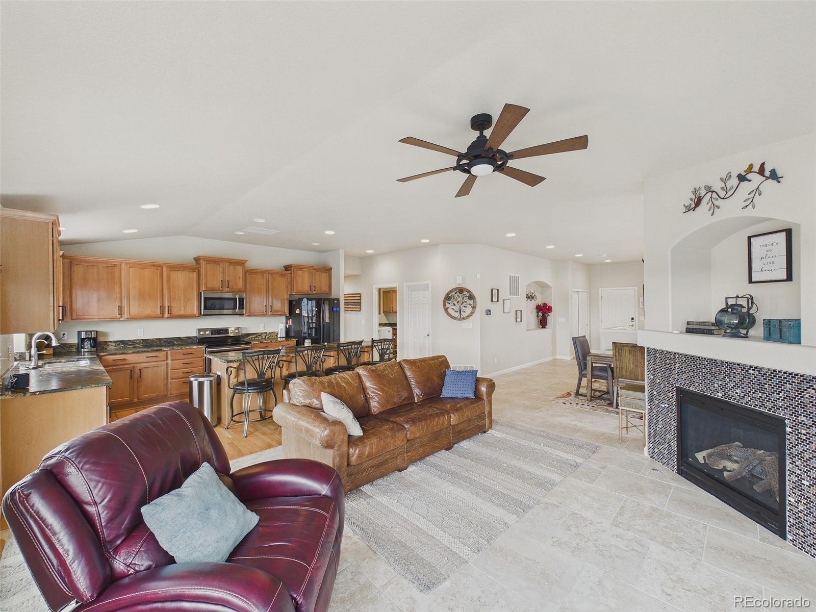 2805 South Jebel Way Aurora, CO 80013 - Photo 14 of 50 a living room with furniture a fireplace and kitchen view