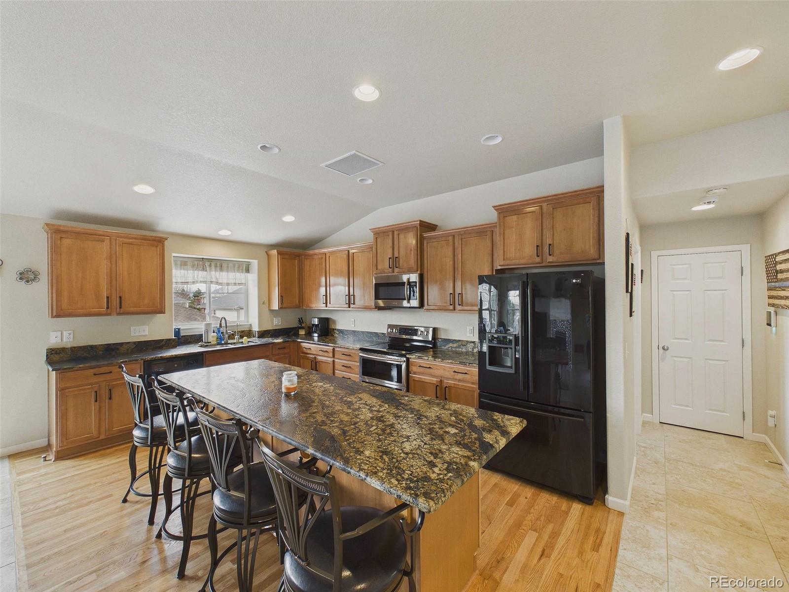 2805 South Jebel Way Aurora, CO 80013 - Photo 15 of 50 a kitchen with stainless steel appliances granite countertop a stove a refrigerator a oven a sink a dining table and chairs