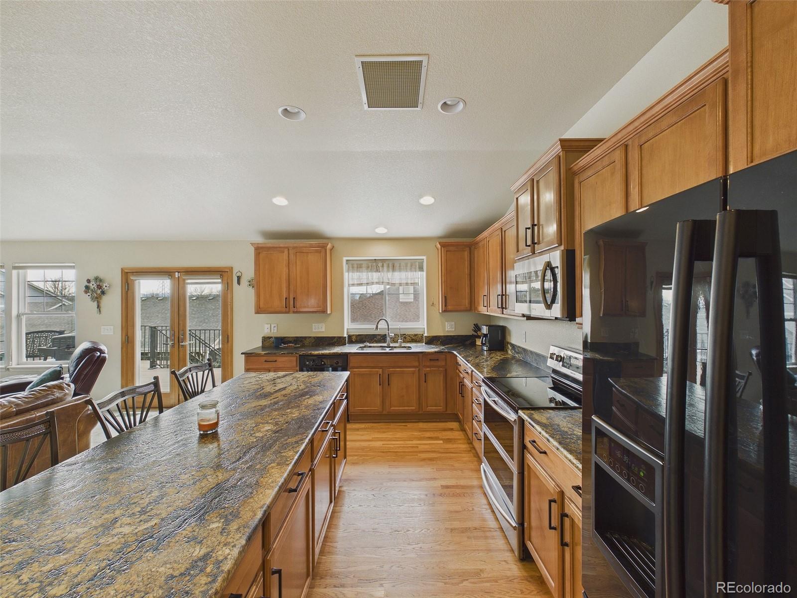 2805 South Jebel Way Aurora, CO 80013 - Photo 17 of 50 a large kitchen with a large window and stainless steel appliances