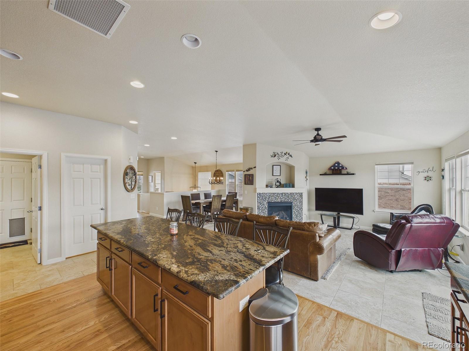 2805 South Jebel Way Aurora, CO 80013 - Photo 19 of 50 a living room with stainless steel appliances granite countertop furniture a fireplace a flat screen tv and a kitchen view