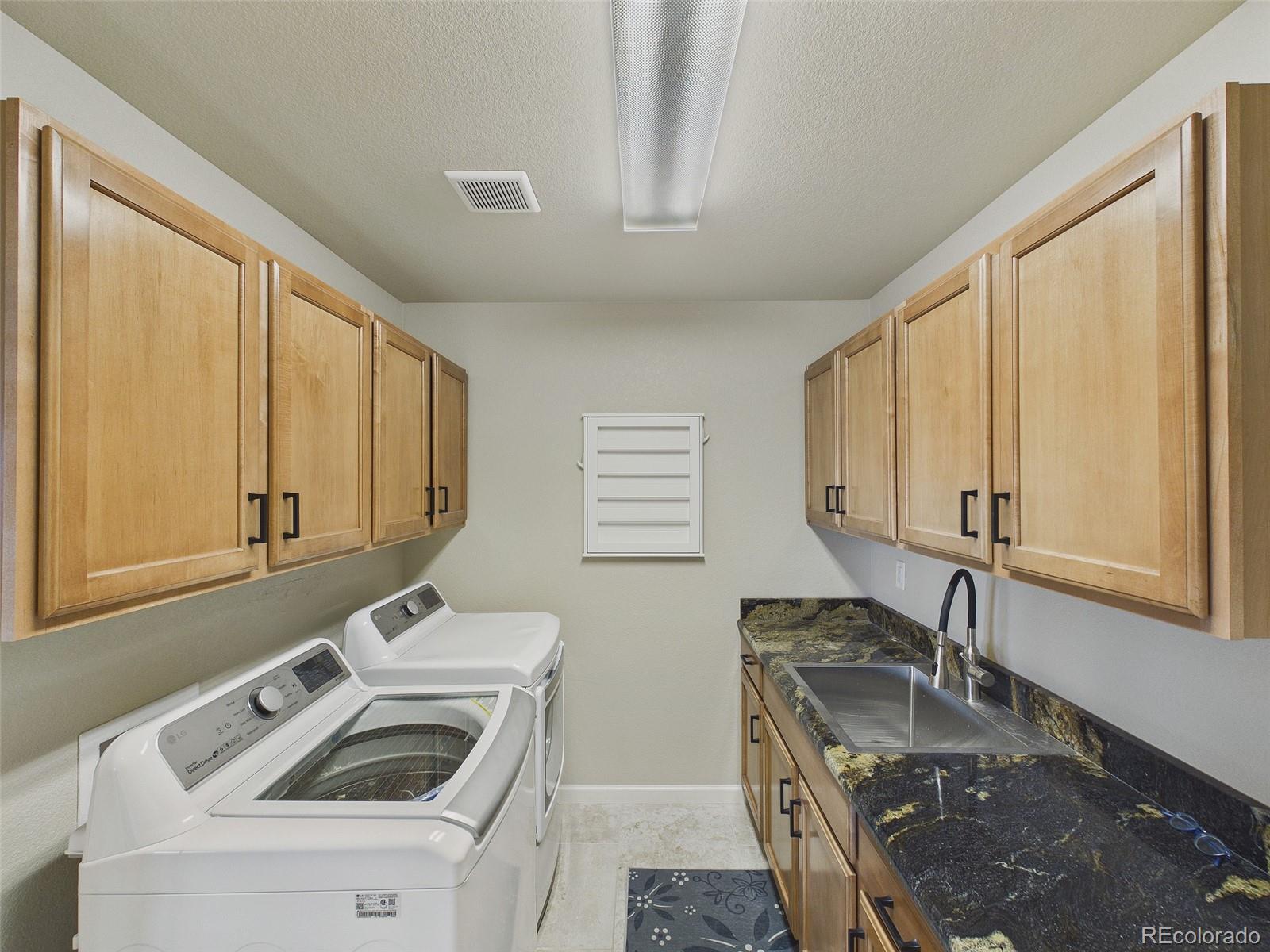 2805 South Jebel Way Aurora, CO 80013 - Photo 22 of 50 a bathroom with a sink a washer and dryer