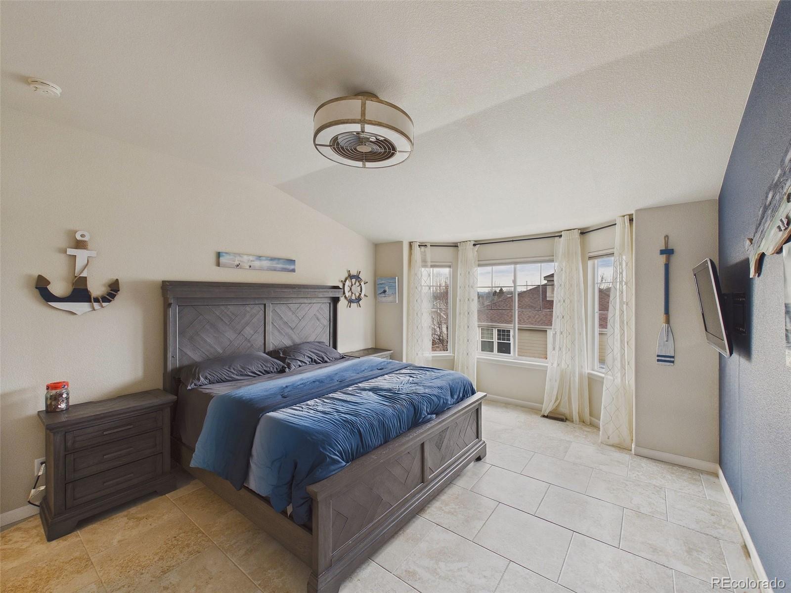2805 South Jebel Way Aurora, CO 80013 - Photo 26 of 50 a bedroom with a large bed and a flat tv screen on dresser