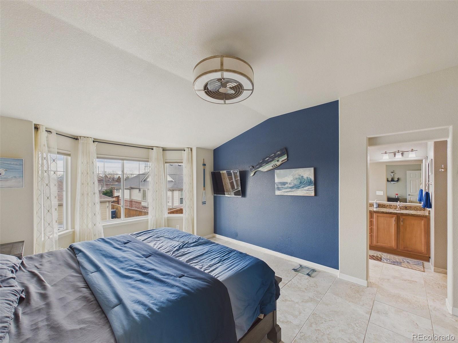 2805 South Jebel Way Aurora, CO 80013 - Photo 29 of 50 a bedroom with a large bed and a chandelier