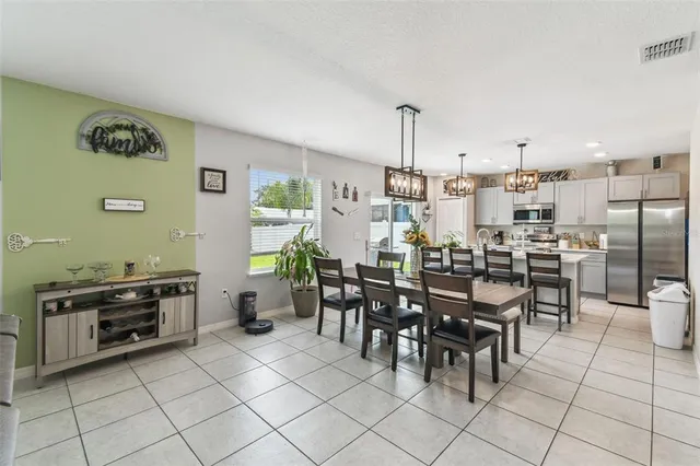 a view of a dining room with furniture a chandelier and wooden floor