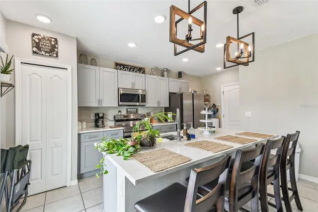 a kitchen with stainless steel appliances granite countertop a kitchen island a stove a table and chairs