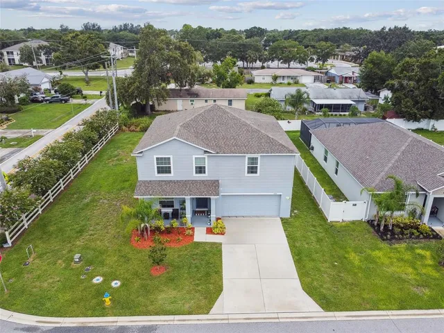 an aerial view of residential houses with outdoor space and parking