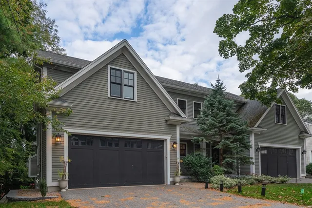 a front view of house with yard and trees in the background