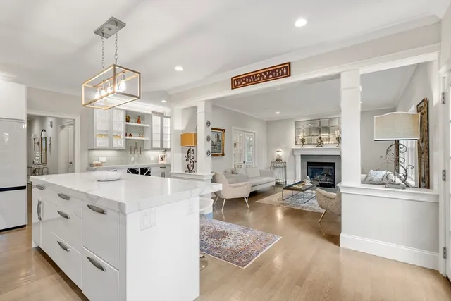 a living room with fireplace furniture and a kitchen view