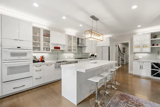 a kitchen that has a lot of cabinets in it and wooden floors