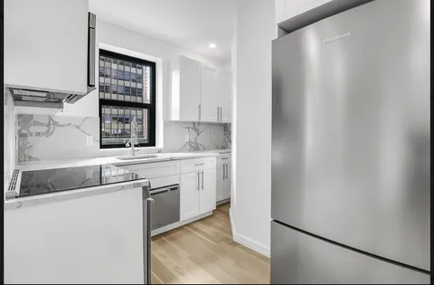 a kitchen with a sink cabinets and window