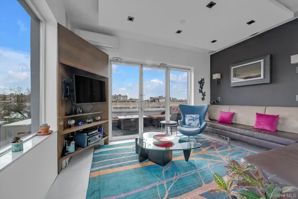 a living room with furniture a flat screen tv and floor to ceiling window