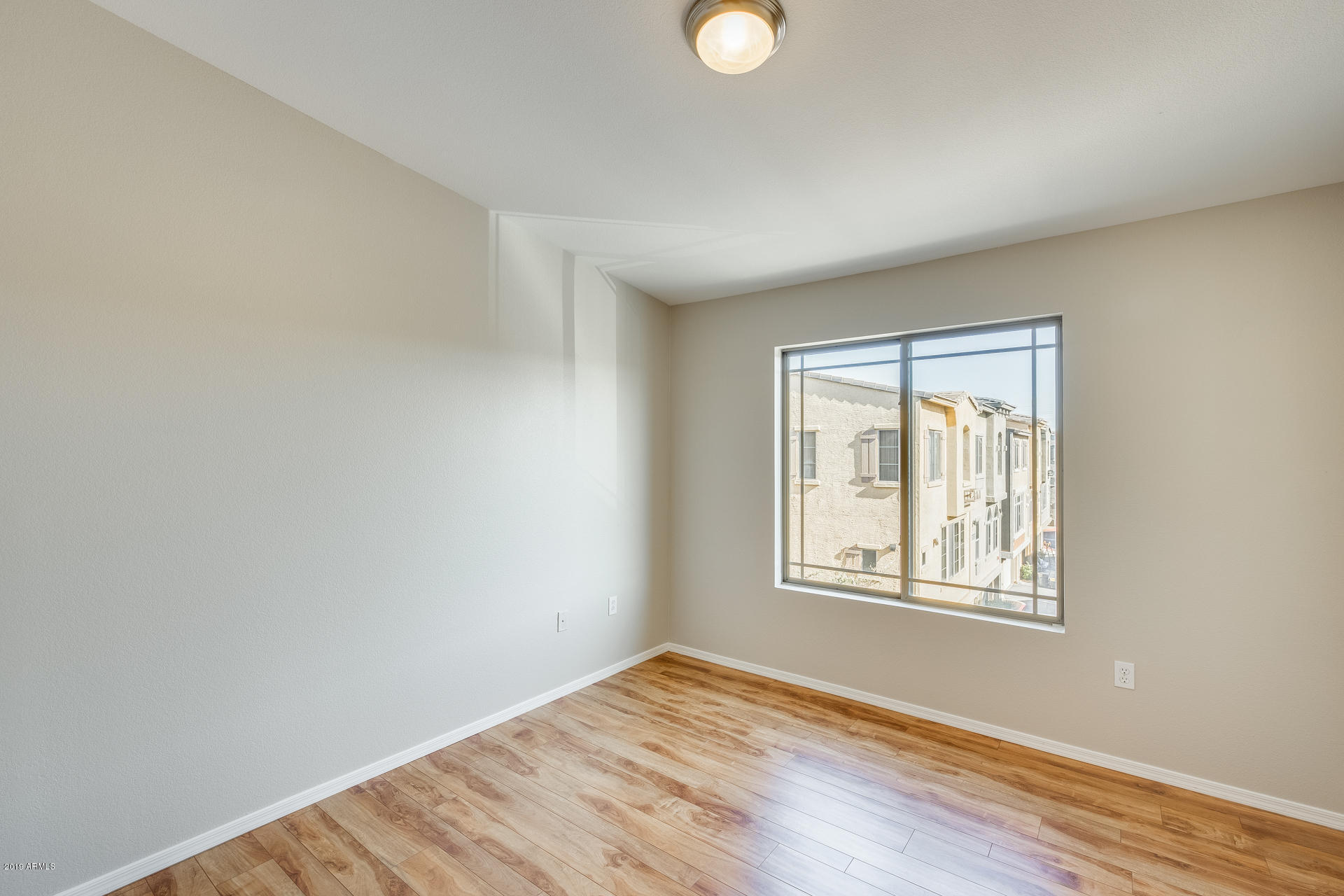 2401 East Rio Salado Parkway, Unit 1124 Tempe, AZ 85288 - Photo 24 of 32 a view of an empty room with wooden floor and a window