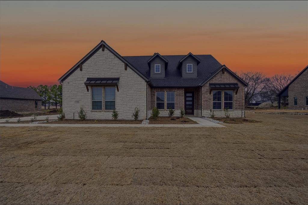 Craftsman-style house with stone siding and a yard