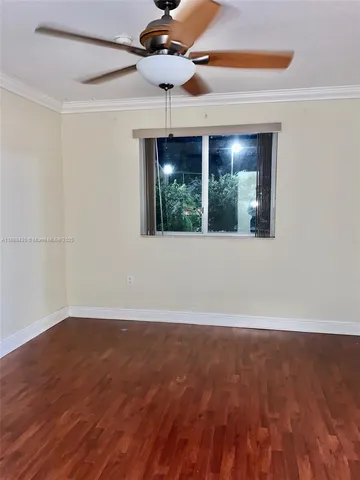en empty room with wooden floor fan and window