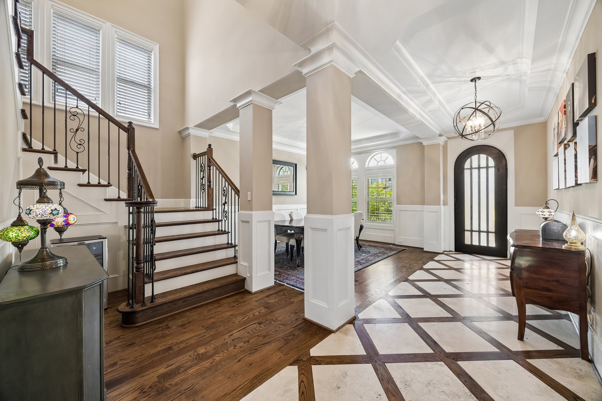 1360 Chippendale Road Houston, TX 77018 - Photo 6 of 34 Beautiful view showcasing the home's open-concept design and elegant architectural details. Hardwood flooring, crown molding, decorative lighting, and open sightlines connect the entry, dining room, and main living spaces while creating a bright and inviting feel throughout.
