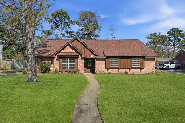 a view of a yard in front of a house with large trees