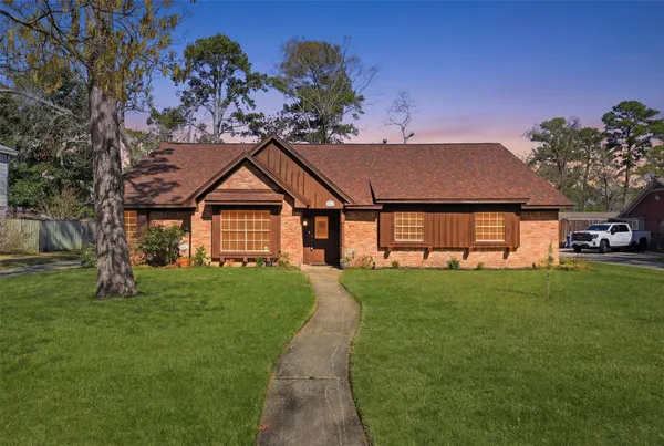 a view of a house with a big yard plants and large trees