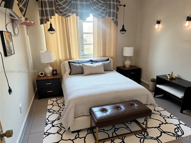 a bedroom with a bed a couch and a potted plant