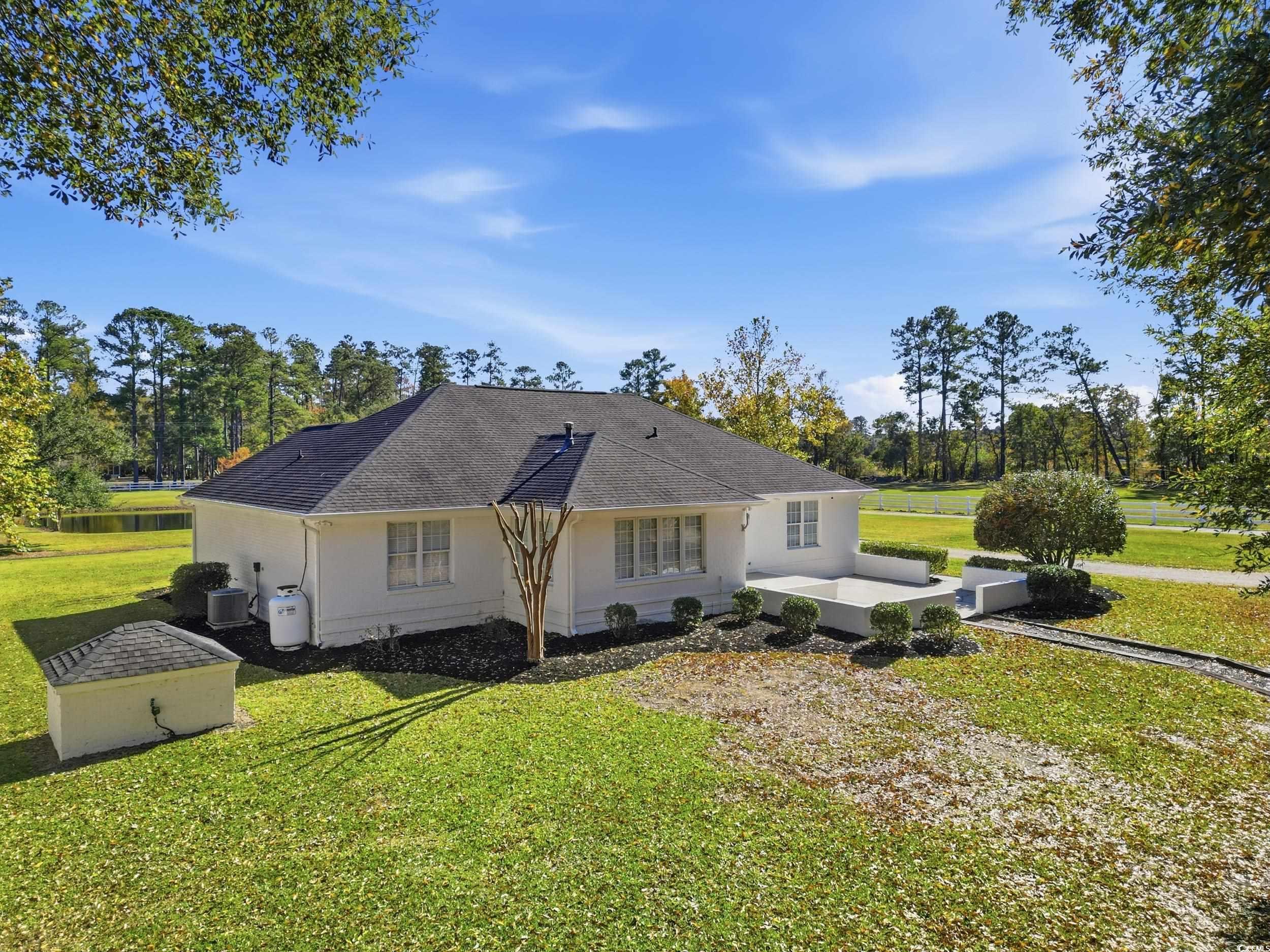 4337 State Highway 65 Conway, SC 29526 - Photo 24 of 39 Rear view of property featuring a lawn, a patio, a shingled roof, stucco siding, and view of scattered trees