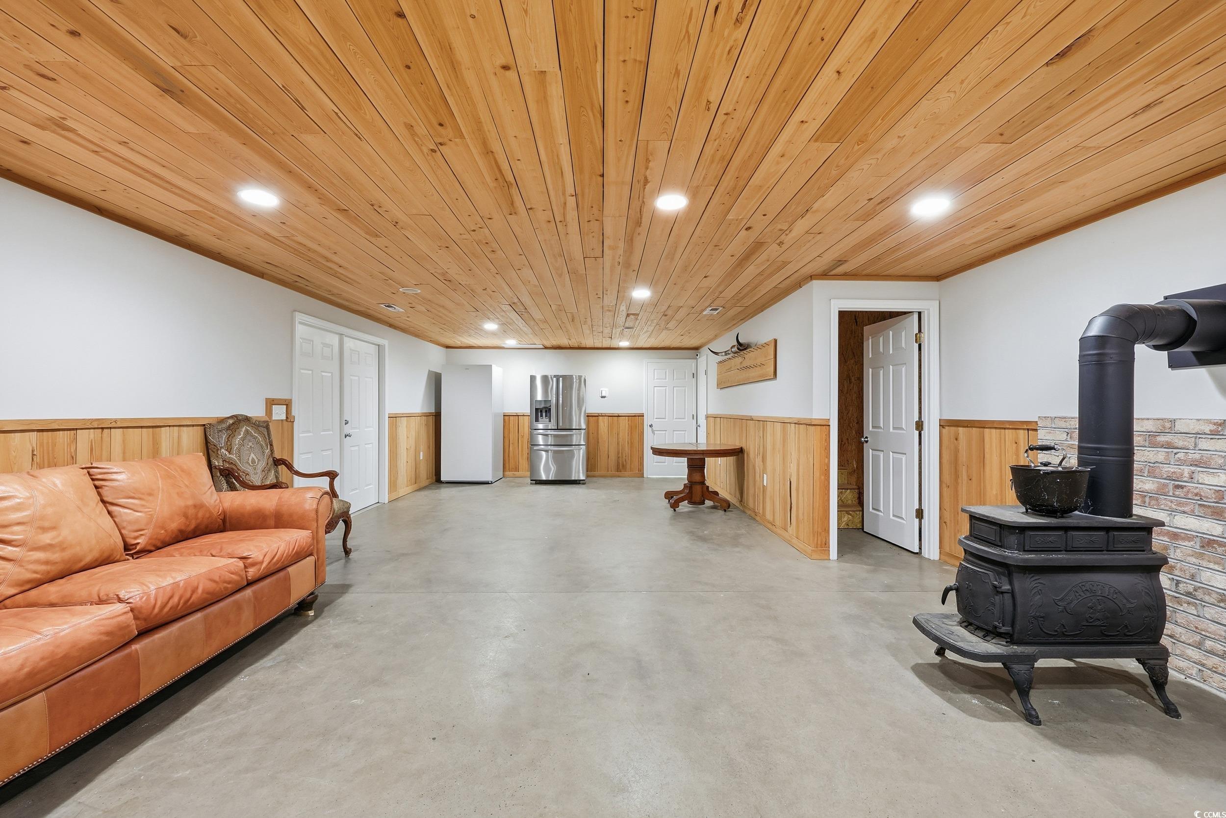 4337 State Highway 65 Conway, SC 29526 - Photo 27 of 39 Living area with wainscoting, a wood stove, recessed lighting, finished concrete flooring, and wooden walls