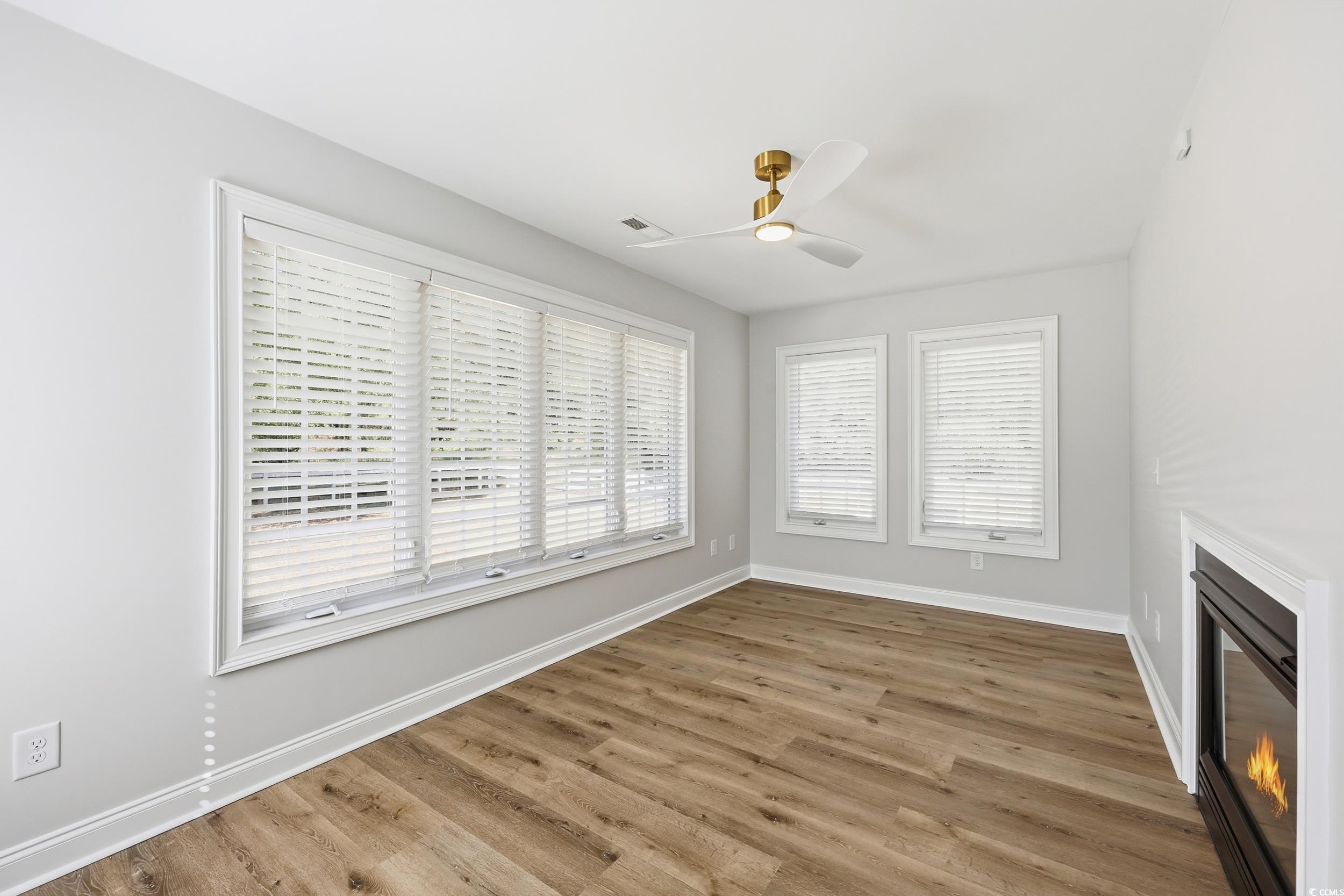 4337 State Highway 65 Conway, SC 29526 - Photo 5 of 39 Unfurnished living room with light wood-type flooring, a glass covered fireplace, and a ceiling fan
