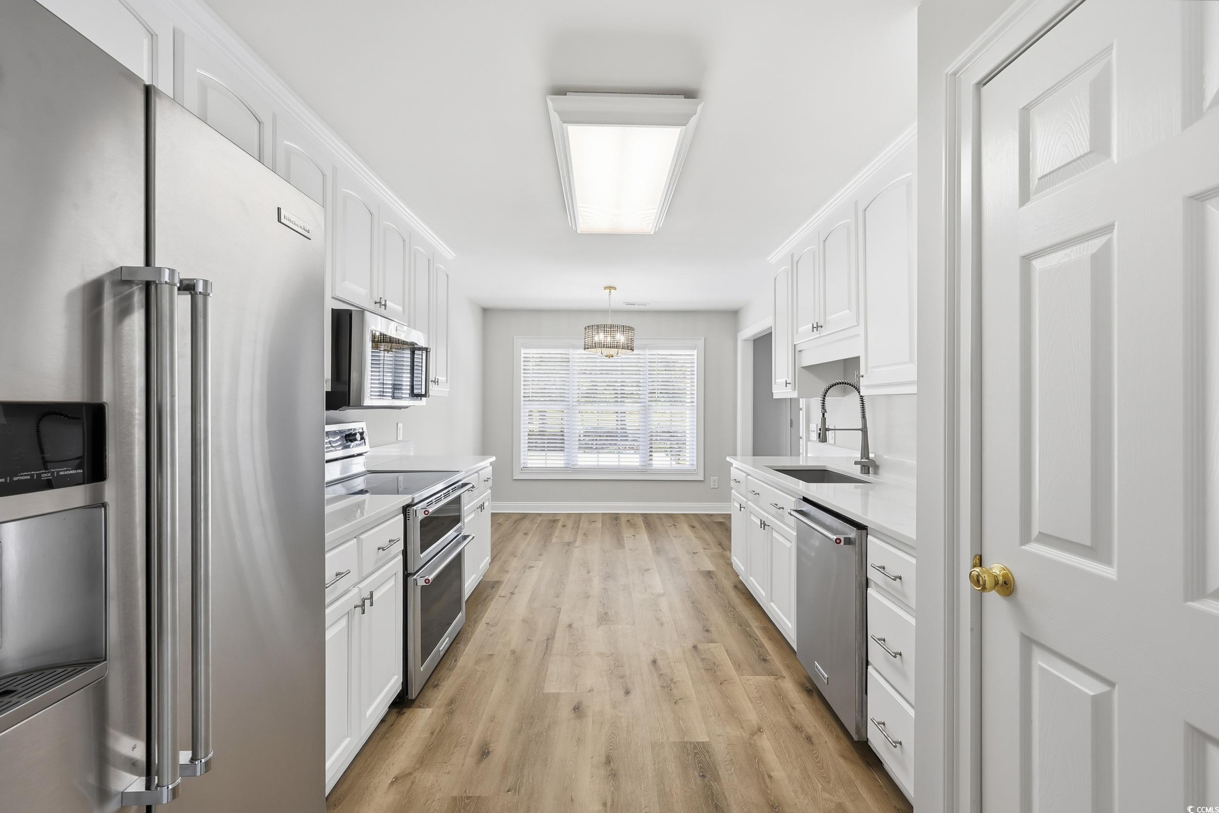 4337 State Highway 65 Conway, SC 29526 - Photo 8 of 39 Kitchen featuring appliances with stainless steel finishes, light wood finished floors, white cabinets, and a chandelier