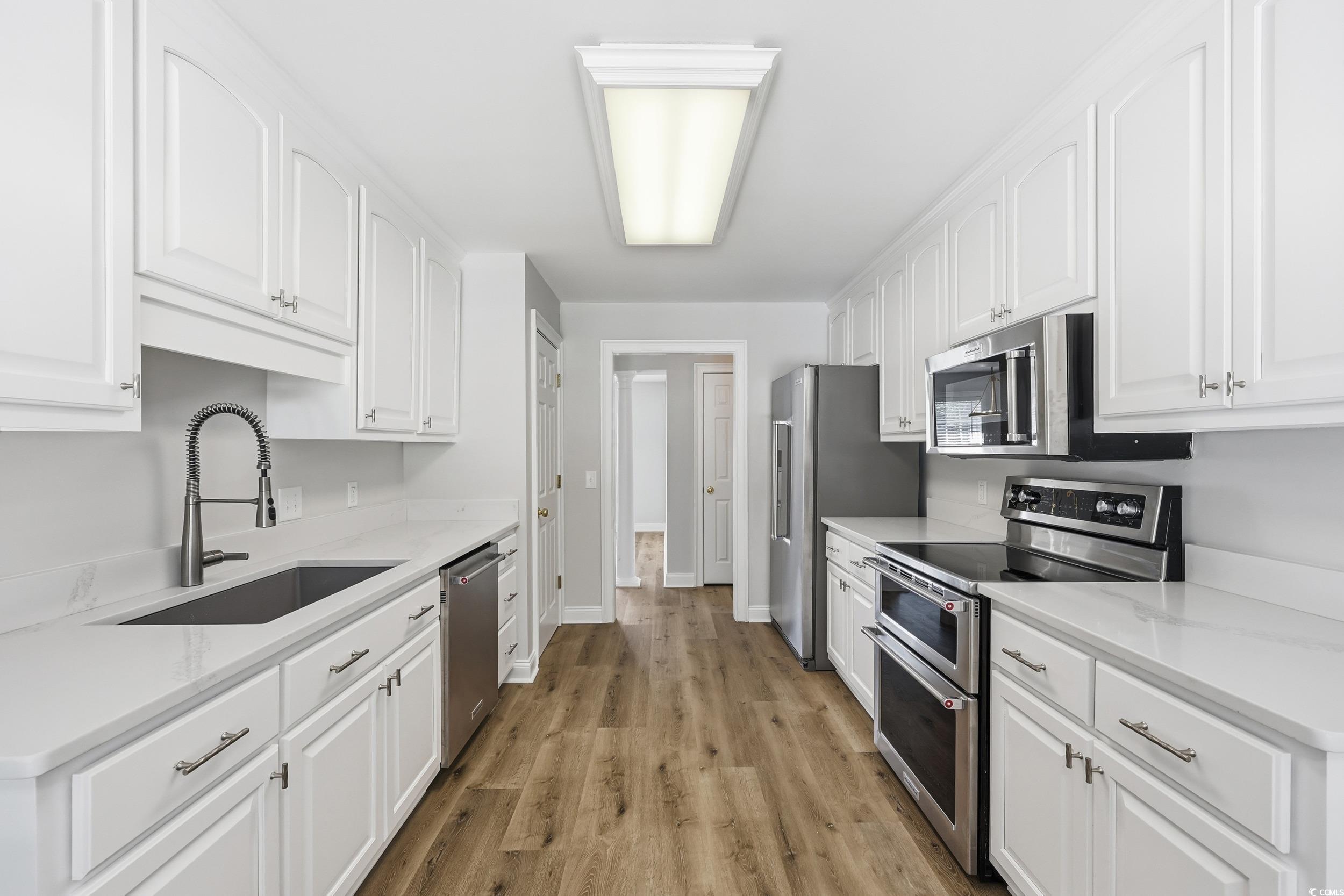 4337 State Highway 65 Conway, SC 29526 - Photo 9 of 39 Kitchen with stainless steel appliances, white cabinetry, and light wood finished floors
