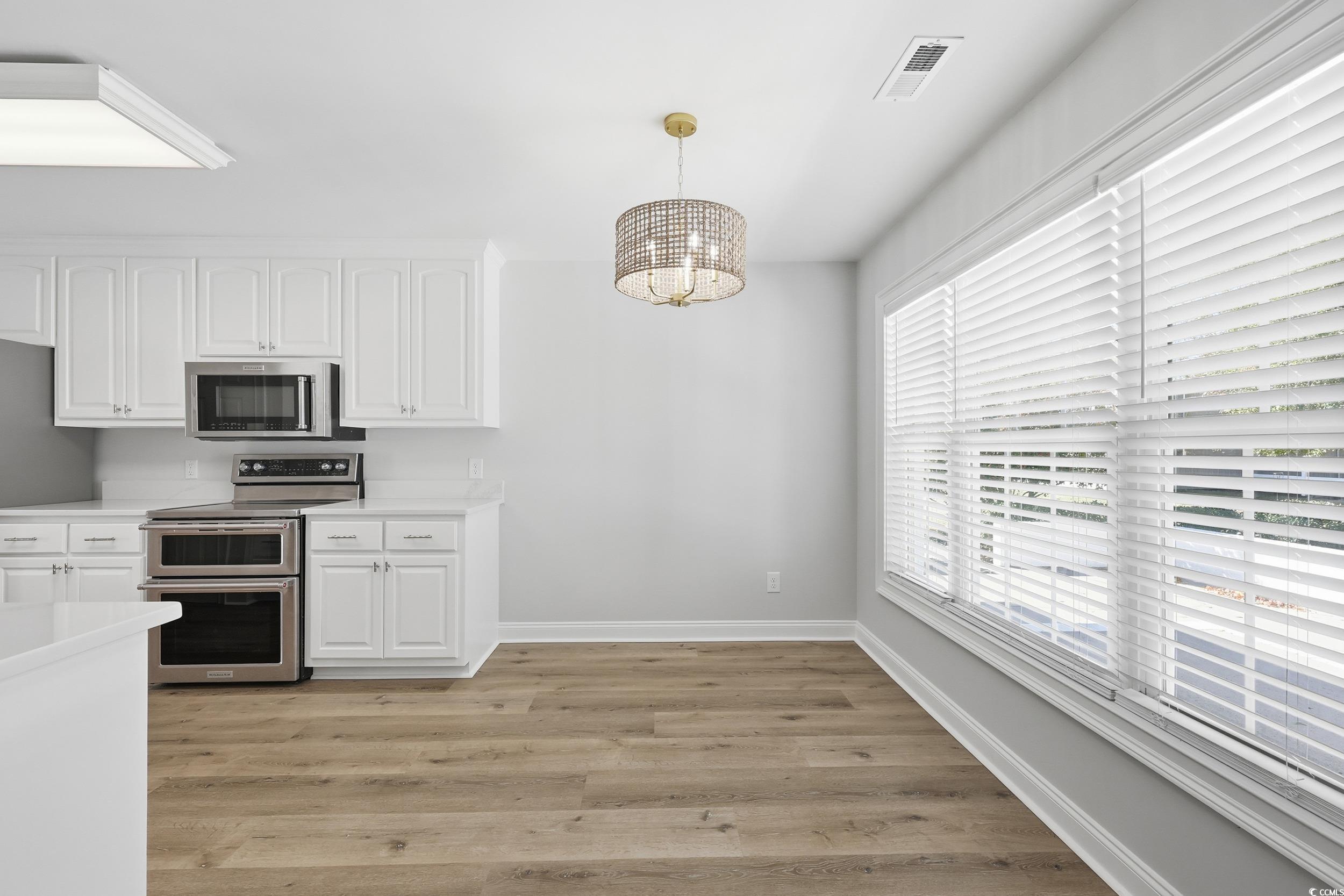 4337 State Highway 65 Conway, SC 29526 - Photo 10 of 39 Kitchen with white cabinets, stainless steel appliances, a chandelier, light wood-style floors, and pendant lighting