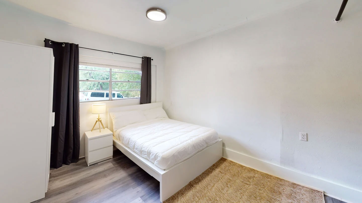 1109 Gardner Cove Austin, TX 78721 - Photo 11 of 13 A well-lit bedroom with durable flooring and ample natural light.