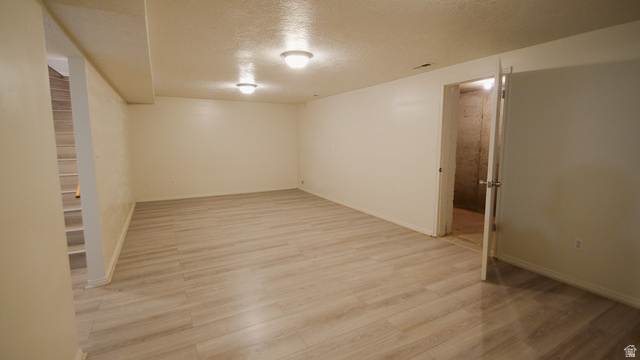 2455 South Bluff Road Syracuse, UT 84075 - Photo 22 of 32 Spacious room featuring light-toned wood-finish flooring, white walls, and flush-mount ceiling lighting