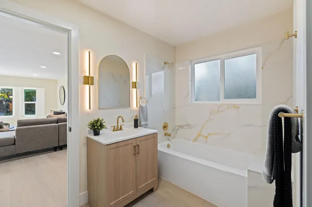 a bathroom with a tub sink and mirror