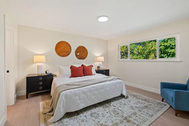a bedroom with a bed and painting on the wall