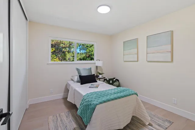 a bedroom with a bed and a painting on the wall