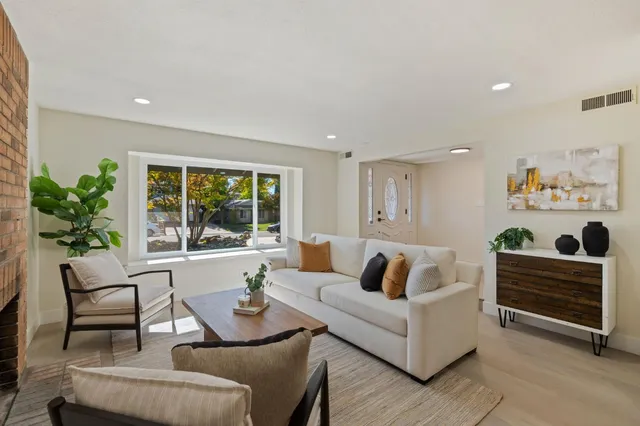 a living room with furniture and a painting on the wall