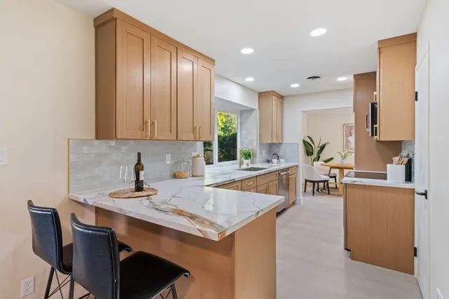 a kitchen with a table chairs sink and cabinets