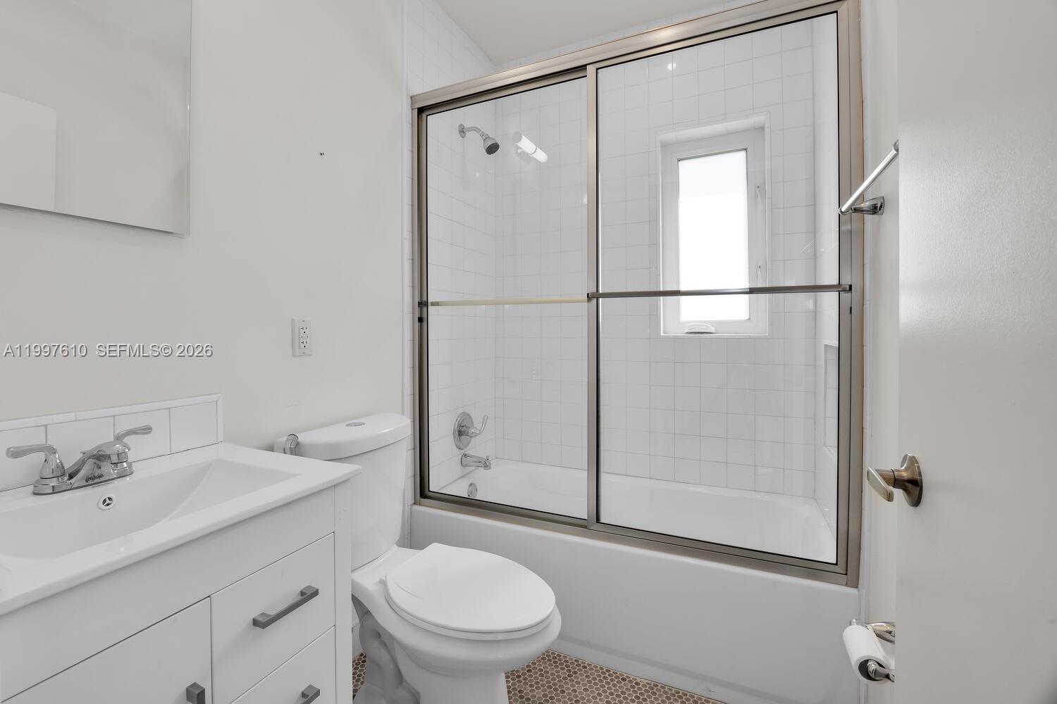 5510 Southwest 76th Street, Unit C Miami, FL 33143 - Photo 11 of 14 a bathroom with a sink a mirror toilet and shower