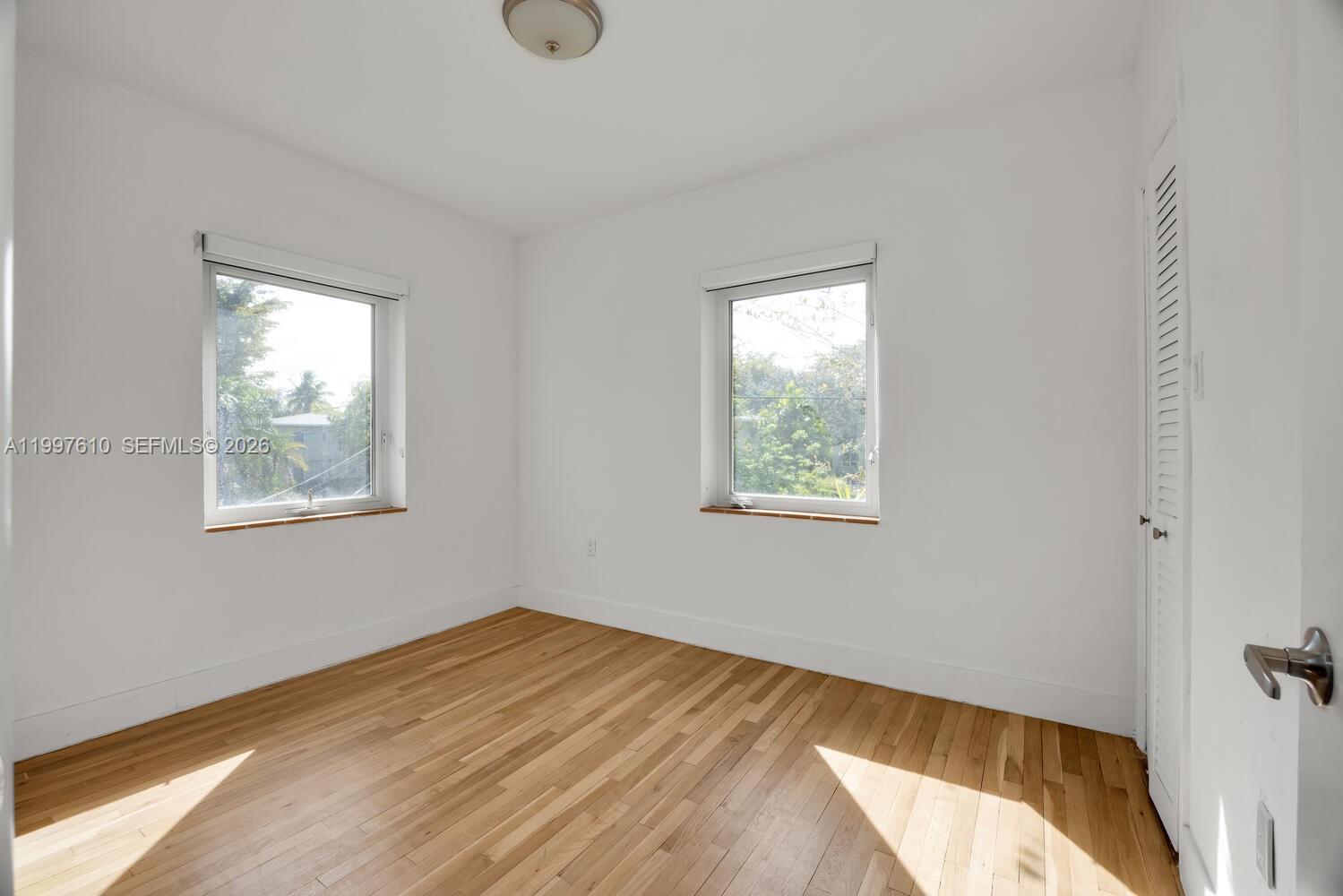 5510 Southwest 76th Street, Unit C Miami, FL 33143 - Photo 13 of 14 a view of a bedroom with wooden floor and window