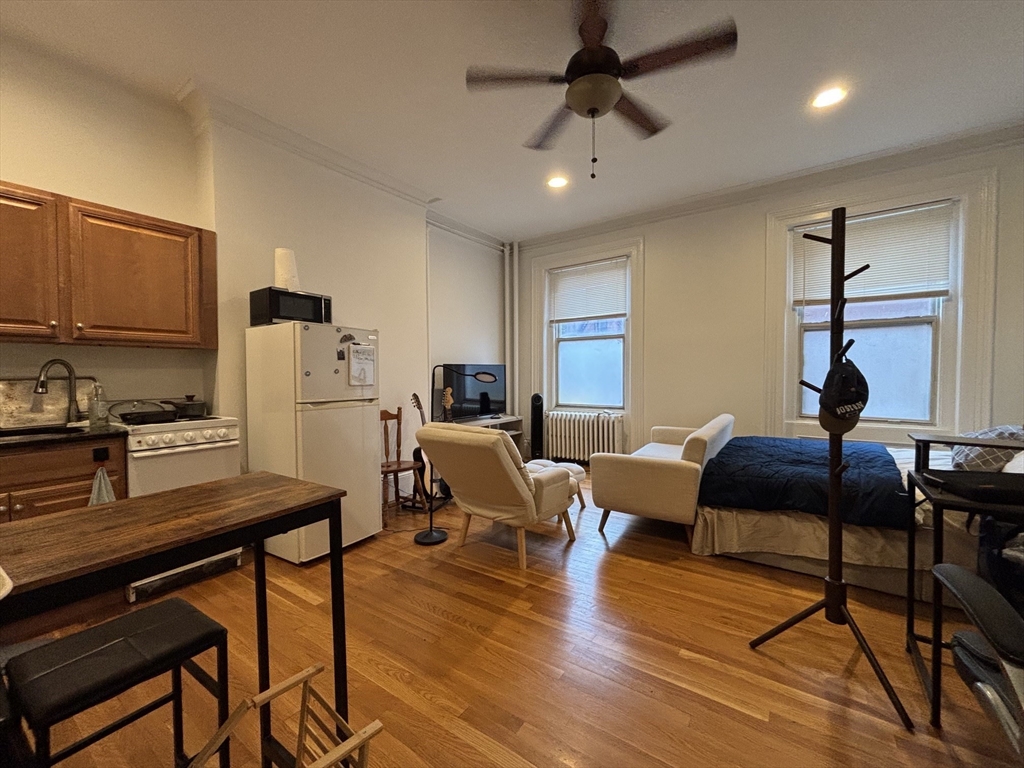 98 Charles Street, Unit 1 Boston, MA 02114 - Photo 1 of 9 a living room with furniture and a wooden floor