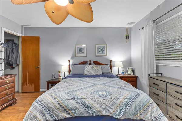 a bedroom with a bed and a flat tv screen on dresser