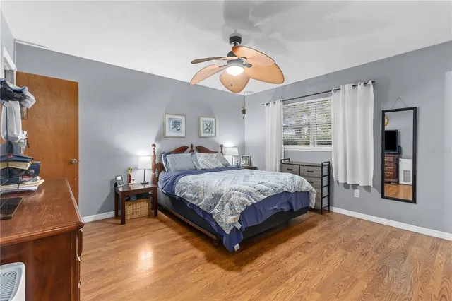 a bedroom with a bed and wooden floor