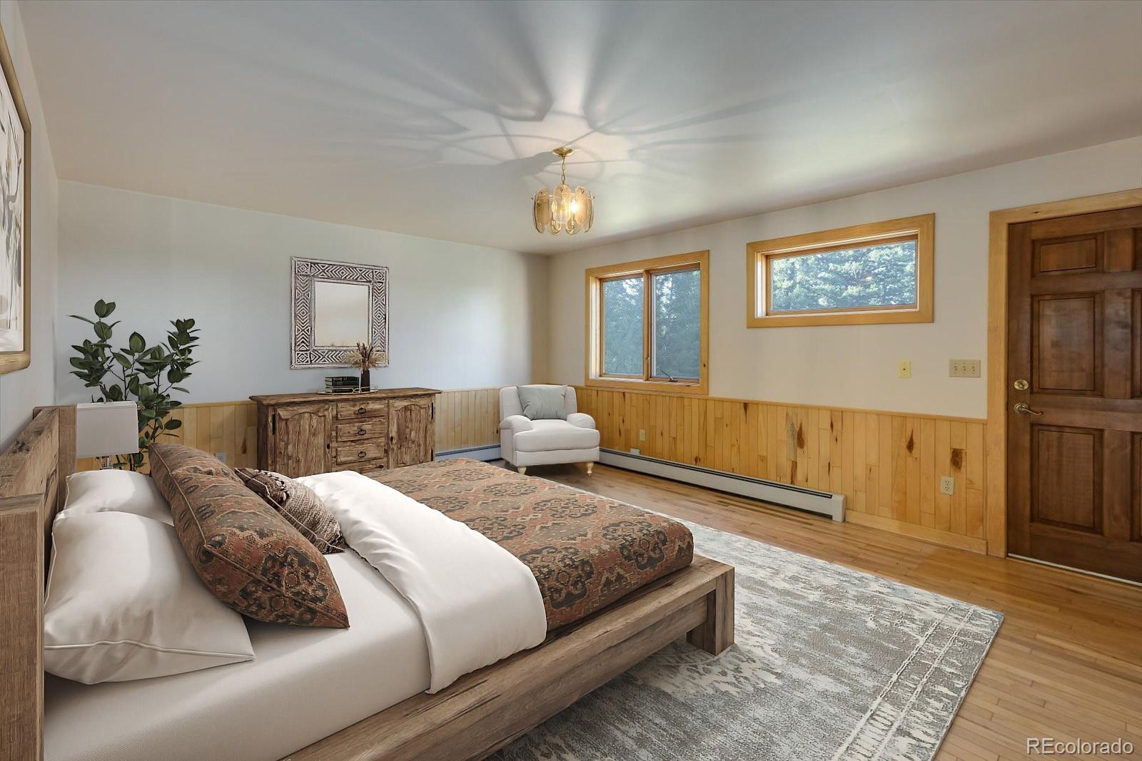 283 Chute Road Golden, CO 80403 - Photo 21 of 40 a bedroom with a large bed and a chandelier