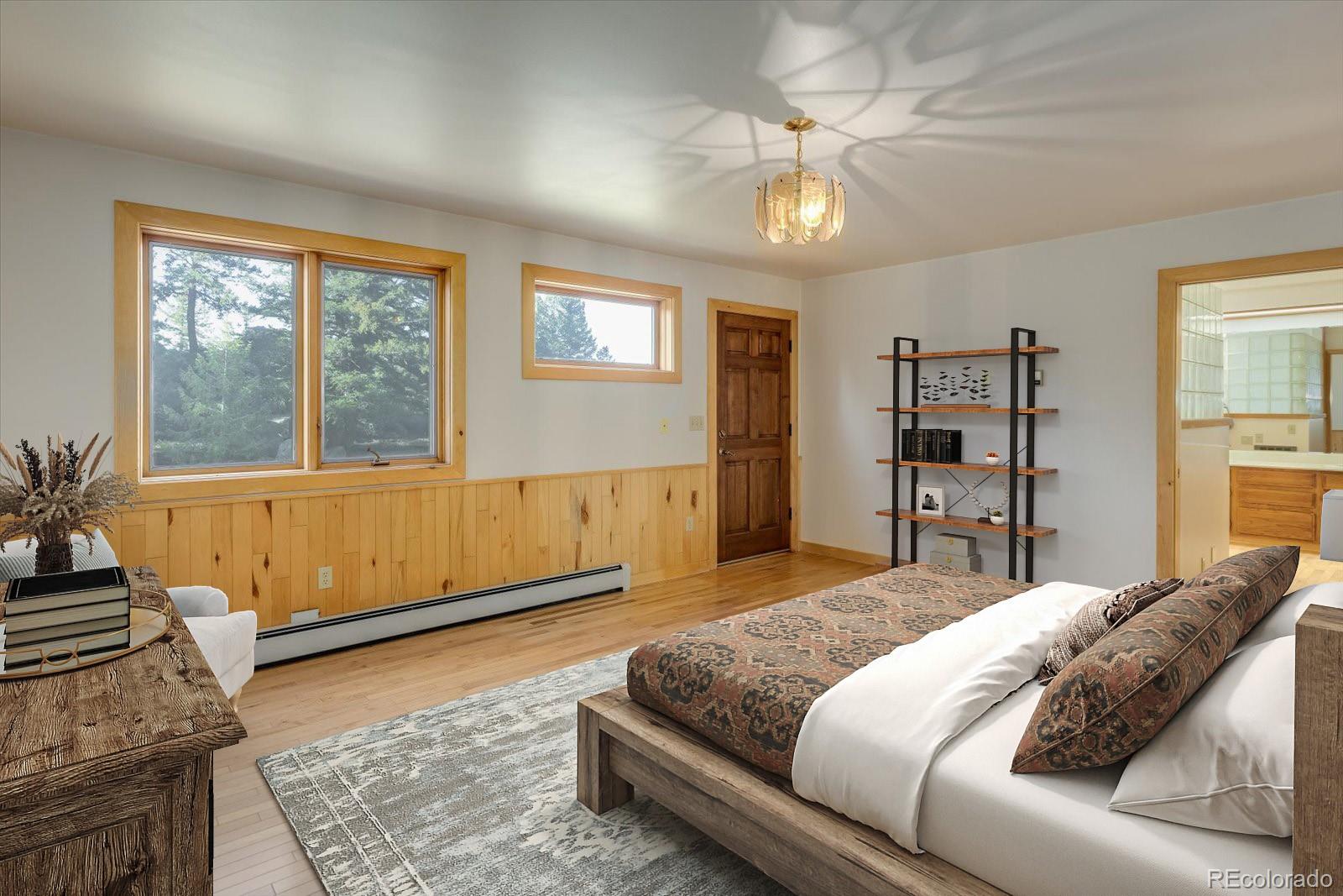 283 Chute Road Golden, CO 80403 - Photo 22 of 40 a spacious bedroom with a large bed and a chandelier